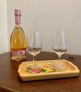 切拉诺B&B Nonno Loreto的切盘上的两杯酒和一瓶葡萄酒