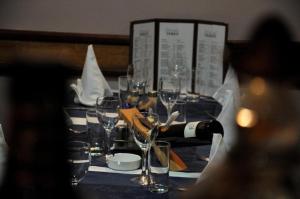 萨拉热窝特雷克斯酒店的一张桌子,上面有眼镜和一瓶葡萄酒