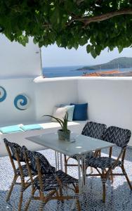 斯基亚索斯镇Oikies Skiathos的一张白色的桌子和椅子,配有一张桌子和一张沙发
