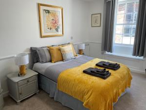 费克纳姆The Crown Fakenham的一间卧室配有一张黄色毯子床