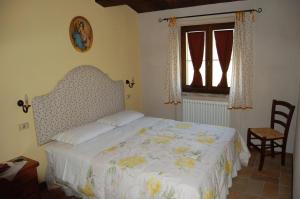 萨尔纳诺安缇卡迪莫拉酒店的卧室配有床、椅子和窗户。