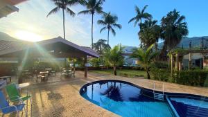乌巴图巴De Bem K Vida的棕榈树屋前的游泳池