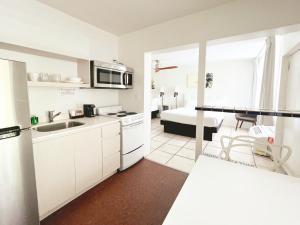 劳德代尔堡Tropi Rock的白色的厨房配有水槽和微波炉
