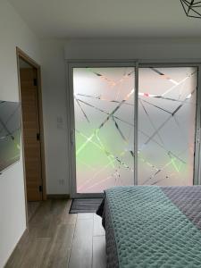 LorgiesLes Chambres de Lily 2的一间卧室设有大玻璃窗和一张床