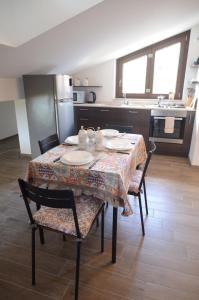 卡普拉科塔FINALMENTE A CASA的厨房配有桌椅和盘子