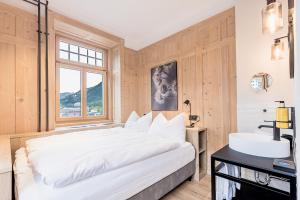达沃斯ALPINE INN Davos的卧室配有白色大床和水槽