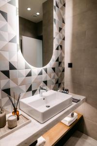 亚历山德鲁波利斯Magico Suites City Heart Luxury Appartments的一间带水槽和镜子的浴室