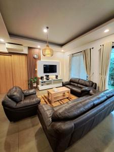 Gadok 1THE OASIS 4BR Private Pool Pet-Friendly Villa Vimala Hills的客厅配有皮革家具和平面电视