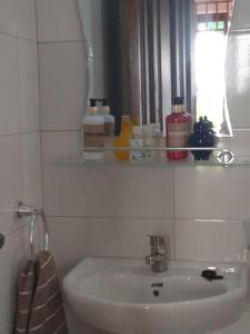 阿克拉Beautiful House Spintex Road Accra的白色的浴室设有水槽和镜子