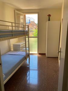卡内·德·玛尔Luminoso apartamento en Canet de Mar cercano a la playa y a Barcelona的客房设有两张双层床和一台冰箱。