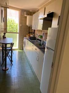 卡内·德·玛尔Luminoso apartamento en Canet de Mar cercano a la playa y a Barcelona的厨房配有白色冰箱和桌子