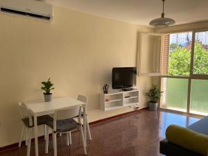 卡内·德·玛尔Luminoso apartamento en Canet de Mar cercano a la playa y a Barcelona的客厅配有白色桌子和电视