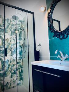 瓦尔米亚地区利兹巴克Apartamenty Krasicki的带淋浴、盥洗盆和镜子的浴室
