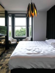 米德尔克尔克Bed & Breakfast Maison Noire Westende-bad incl parking & ontbijt的窗户客房内的一张大白色床