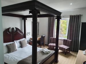 斯特利特威塞克斯酒店的一间卧室配有四柱床和一张书桌