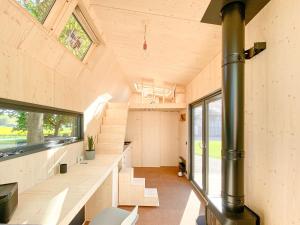 斯泰恩伯格tinyzeit Urlaub im tiny house an der Flensburger Förde的大房间设有楼梯和大窗户