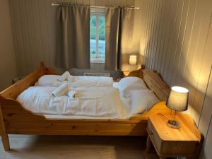 BoverdalenNørdre-Repp的一张带白色床单和窗户的大型木制床
