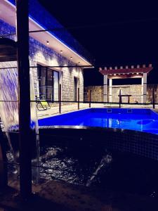 Al ‘AqarAlshafaq chalet的夜间在房子前面的游泳池