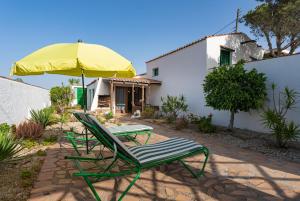 格拉纳迪利亚德亚沃纳坎普拉尼娅卡萨乡村酒店的庭院设有两把草坪椅和一把遮阳伞