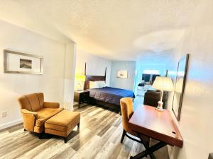 Bayou La BatreBayou Inn & Suites的酒店客房,配有一张床、一张桌子和椅子