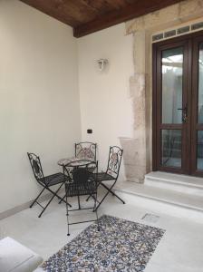 锡拉库扎Al Settimo porta marina的一个带桌椅的庭院和一个窗户。