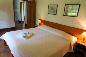 多拉杜Hotel Fazenda Bela Vista的卧室配有白色的床和2条毛巾