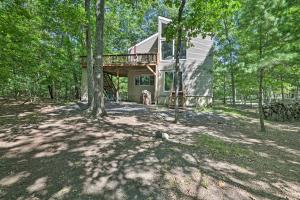 东斯特劳兹堡Lakefront Poconos Cottage - Deck, Fire Pit and Grill的树林中带甲板的房子