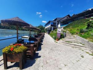 梅德沃代格斯提赛兹洛住宿加早餐旅馆的河边的一排桌子和遮阳伞