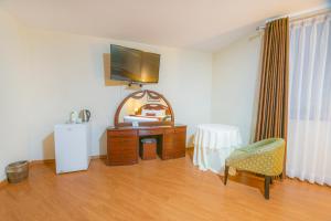 利马米拉弗洛雷斯科隆酒店的配有电视、梳妆台和椅子的房间