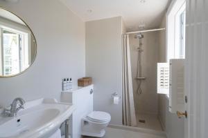 古兹耶姆Melsted Badehotel的一间带水槽、卫生间和镜子的浴室