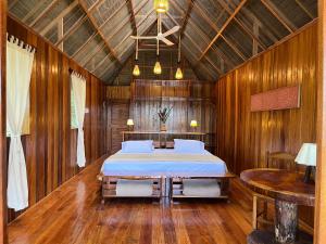 马尔多纳多港Sotupa Eco Lodge的木制客房内的一间卧室,配有一张床