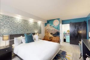 阿尔伯克基Hotel ZAZZ的卧室配有白色大床和蓝色的墙壁