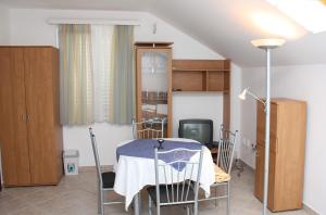 斯拉诺Apartments with a parking space Slano, Dubrovnik - 3184的一间带桌椅和电视的用餐室