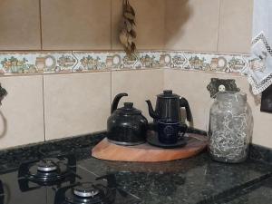 库里提巴Espaço Jardim Curitiba的厨房柜台上有两个茶壶和玻璃罐