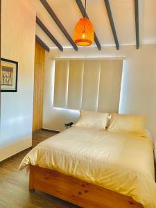 佛罗里达布兰卡Ruitoque Apartamento Campestre Maravillosa Vista的一间卧室配有一张带灯具的白色床