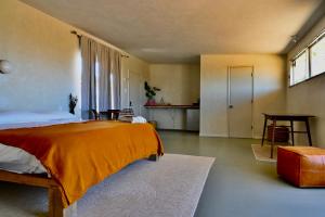 沙漠温泉Miracle Manor Boutique Hotel & Spa的一间卧室配有一张带橙色毯子的大床