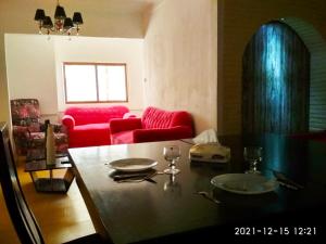 亚历山大Nice house的客厅配有桌子和红色沙发