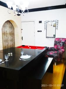 亚历山大Nice house的一间用餐室,配有一张黑桌子和一把椅子