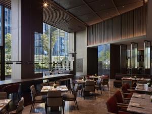 杭州杭州良渚洲际酒店的餐厅设有桌椅和大窗户。