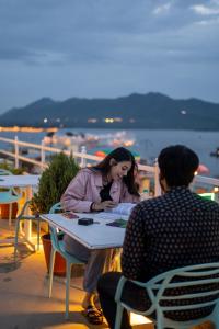 乌代浦Citylights By MUSAFIR的坐在桌子上与男人说话的女人