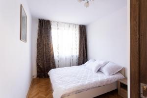 特尔古穆列什Central Apartment Targu Mures的卧室配有白色的床和窗户。