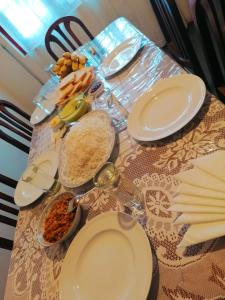 努沃勒埃利耶Nuwara eliya mountain view homestay的餐桌上摆放着白板和碗的食物