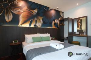 马六甲Trevor Hotel Malacca Town By I Housing的卧室配有一张大床,墙上挂有绘画作品