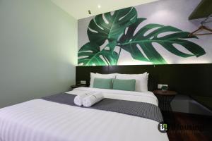 马六甲Trevor Hotel Malacca Town By I Housing的卧室配有带毛巾的大型白色床