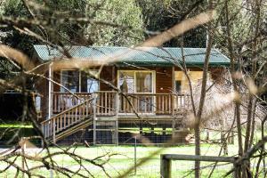 德洛兰Drumreagh Cabins的小木屋设有门廊和绿色屋顶