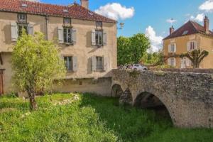 努瓦埃尔confortable maison familiale à l'entrée du village médiéval的一座古老的石桥,在一些建筑前