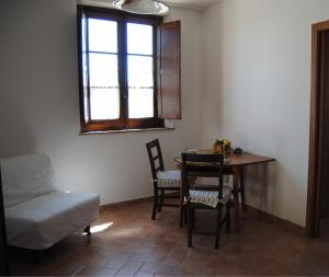 蒙特普齐亚诺波吉亚诺乡村民宿的客厅配有桌椅和窗户。