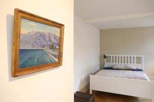 因特拉肯City Center Apartment的卧室配有一张床,墙上挂有绘画作品