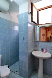 萨兰达Joyous Apartments的一间带水槽、卫生间和镜子的浴室