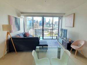墨尔本达克兰海港避静公寓的客厅配有蓝色的沙发和玻璃桌